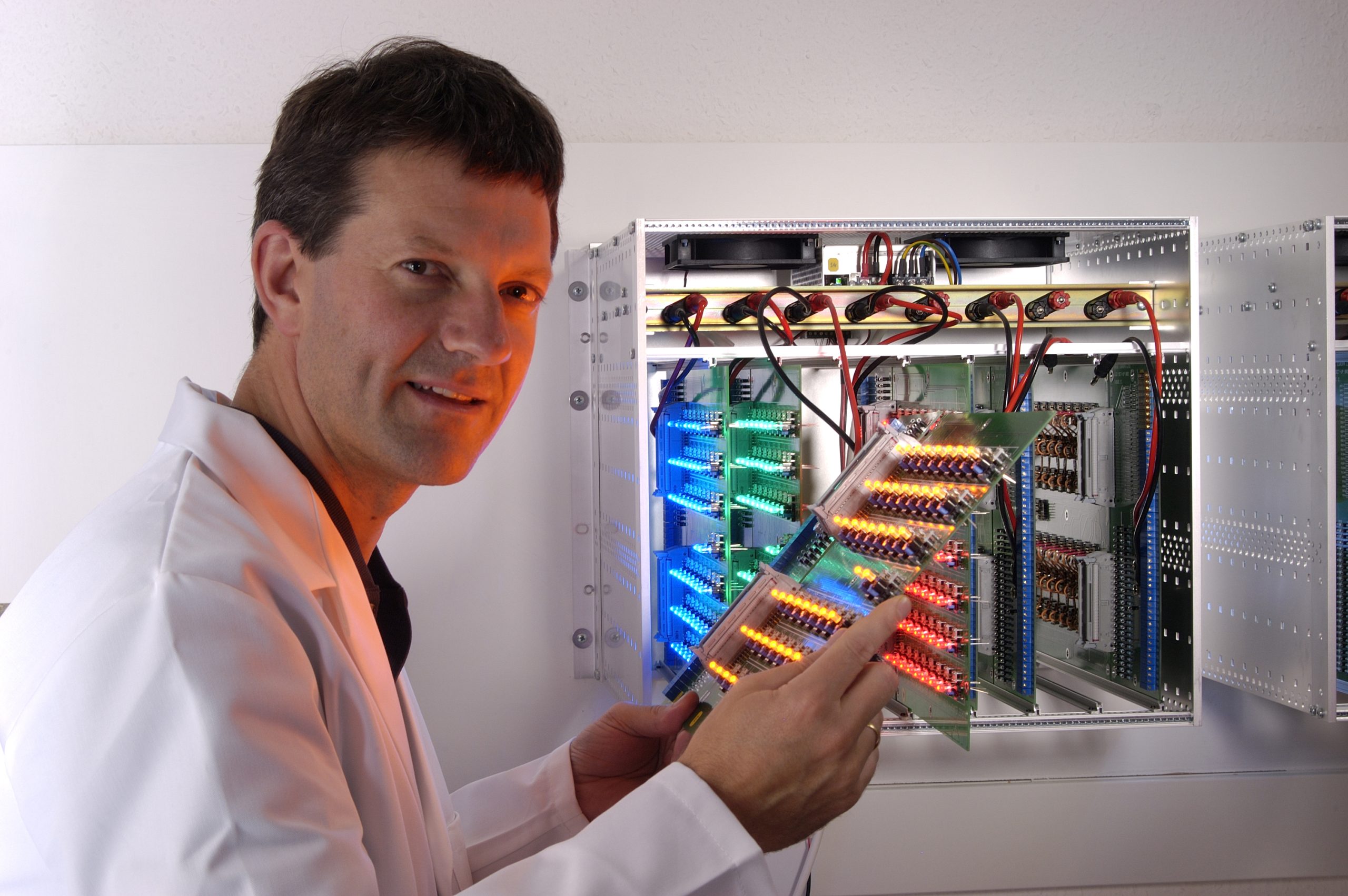 A photograph of Peter Barton standing next to an LED board. Peter Barton is shown in a casual setting, wearing a jumper, with an LED board in the background. The image conveys the concept of casual engagement with LED technology.