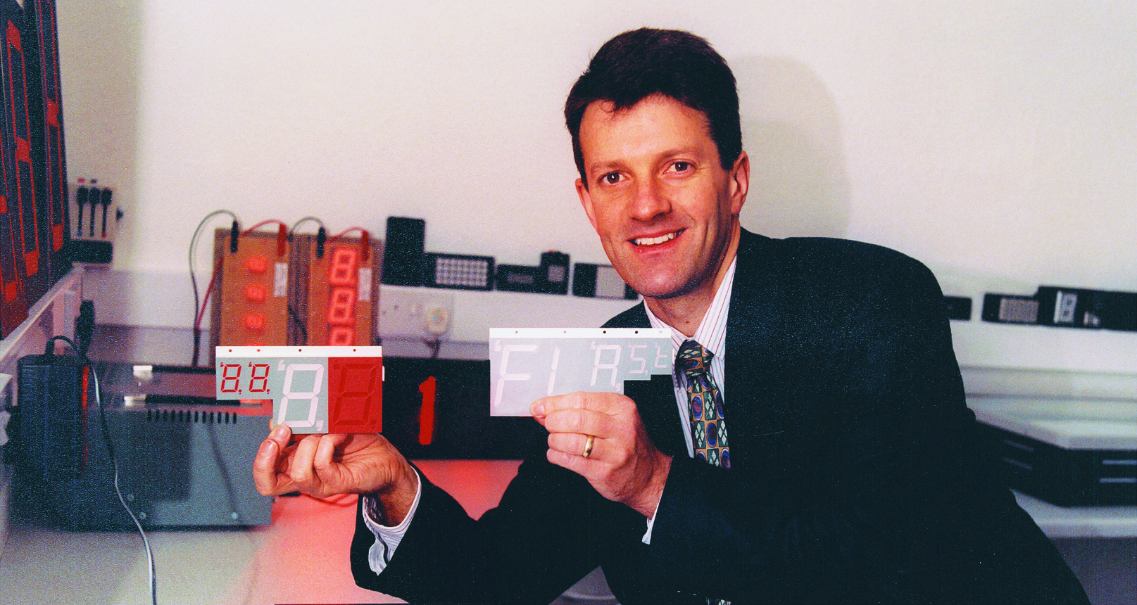An advertisement featuring Peter Barton. The advertisement is displayed on a digital screen or billboard and includes a photograph of Peter Barton along with text. The image conveys the concept of outdoor advertising and promotion.