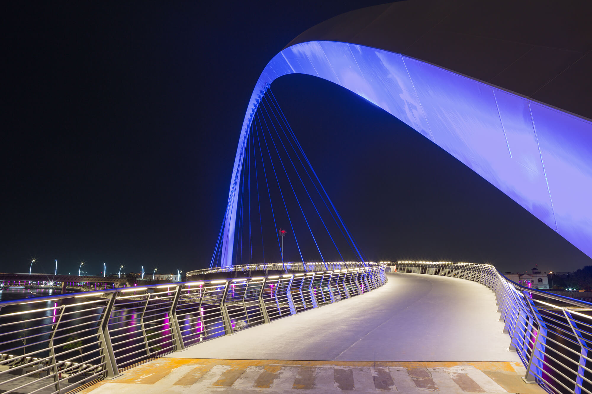 A photograph of a modern bridge spanning over water. The bridge features sleek lines and architectural details, reflecting contemporary bridge design. The image conveys the concept of modern infrastructure and architectural engineering in bridge construction.