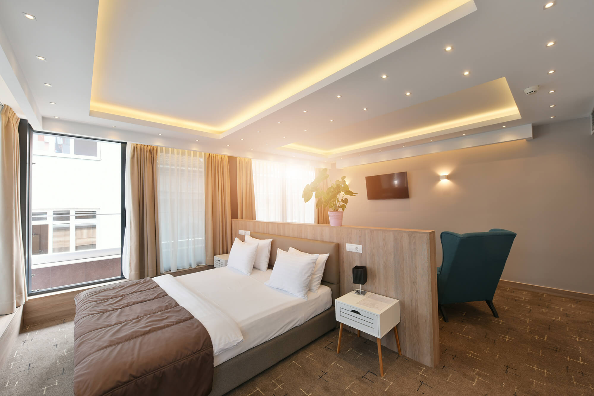 A stylish hotel room with modern furnishings and decor. The room features a comfortable bed with crisp linens, a desk area, and soft lighting. The image conveys the concept of contemporary hotel accommodation and interior design.